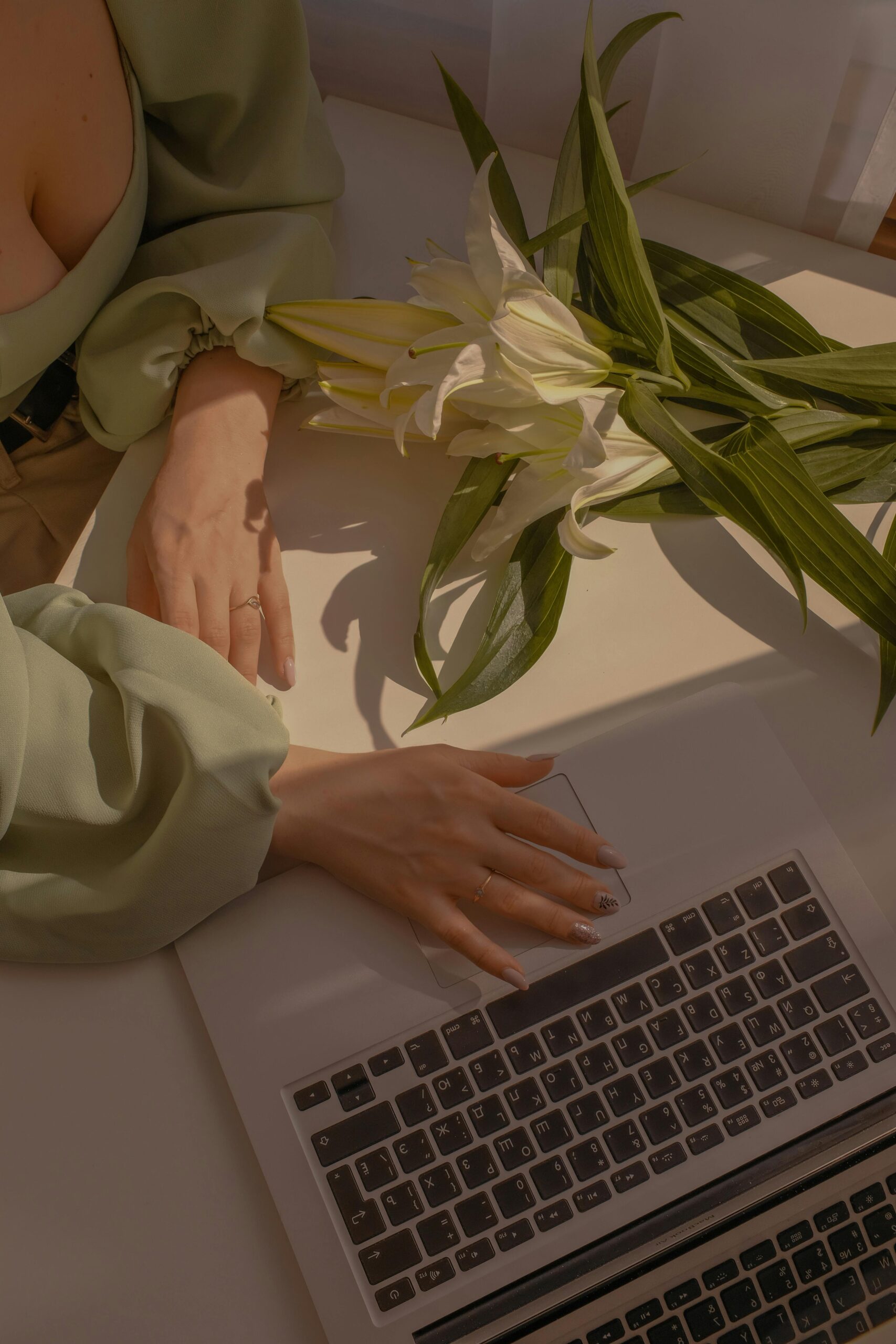 Woman sitting at a laptop in a sunlit space with plants, planning her new website and SEO strategy for a wellness retreat business
